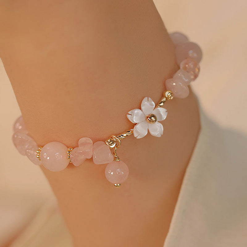 Rosenquarz Armband Kristall – Liebe mit Blütenanhänger am Handgelenk getragen