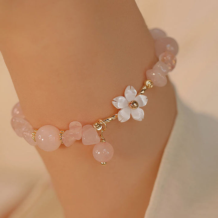 Rosenquarz Armband Kristall – Liebe mit Blütenanhänger am Handgelenk getragen