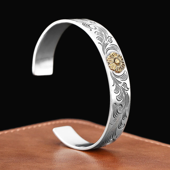 Silbernes Armband mit Blumenmotiv und Gravur auf Leder.