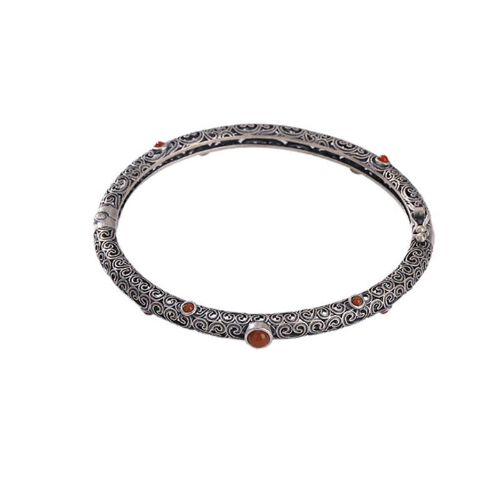 Silbernes Armband mit rotem Achat und ornamentalem Muster elegant.