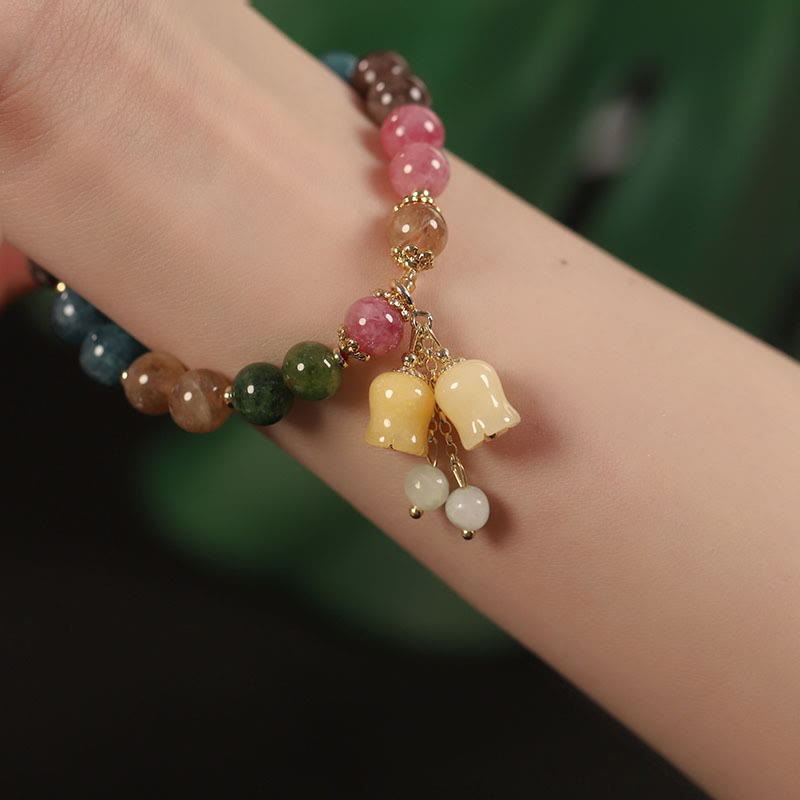 Buntes Tourmalin Armband mit Blume Perle Anhänger am Handgelenk getragen