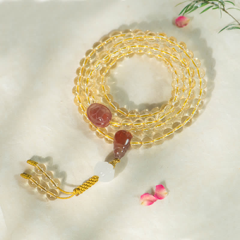 Citrin Mala Perlenarmband mit roten Achat Anhängern auf weißem Hintergrund.
