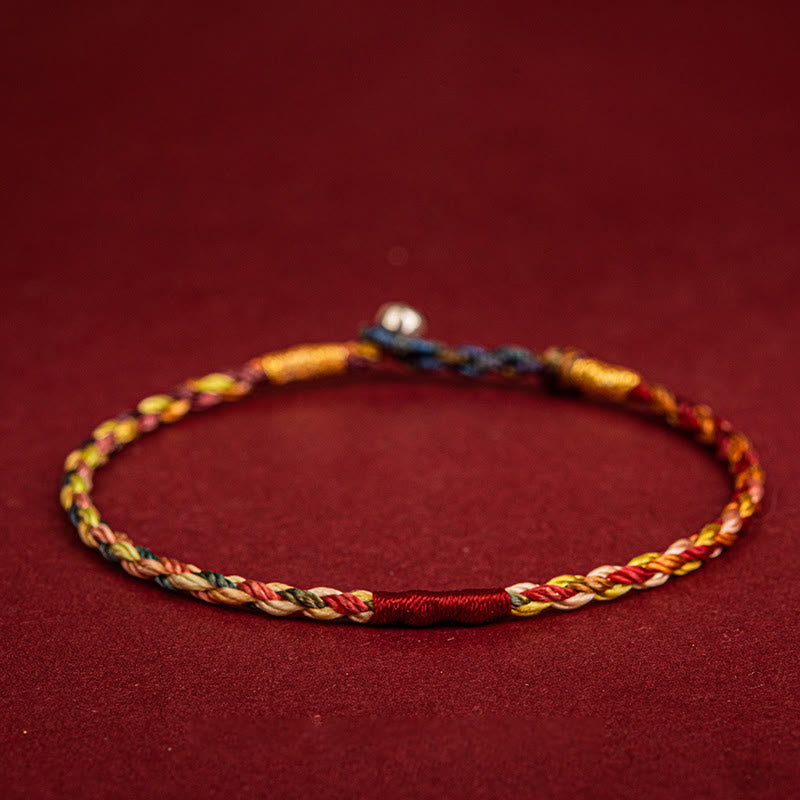 Buntes geflochtenes Armband mit Fünffarben auf rotem Hintergrund, Schutz Glück Armband