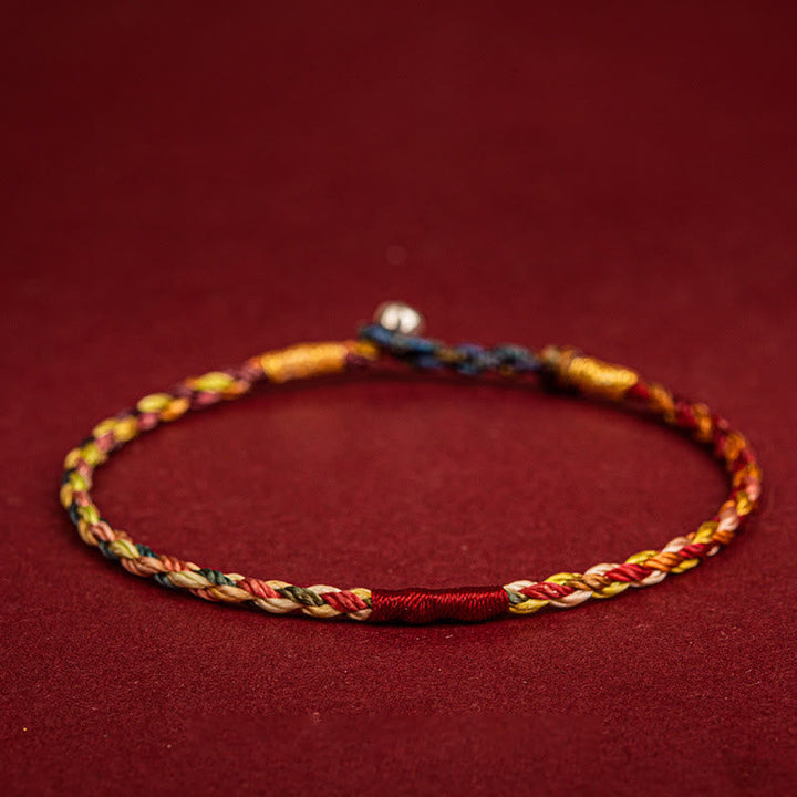 Buntes geflochtenes Armband mit Fünffarben auf rotem Hintergrund, Schutz Glück Armband
