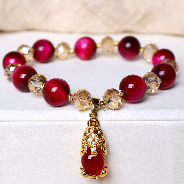 Rotes Armband mit goldenen Perlen und Anhänger elegant.