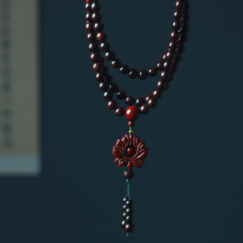Sandelholz Lotus Armband Balance mit roten Perlen Anhänger Nahaufnahme