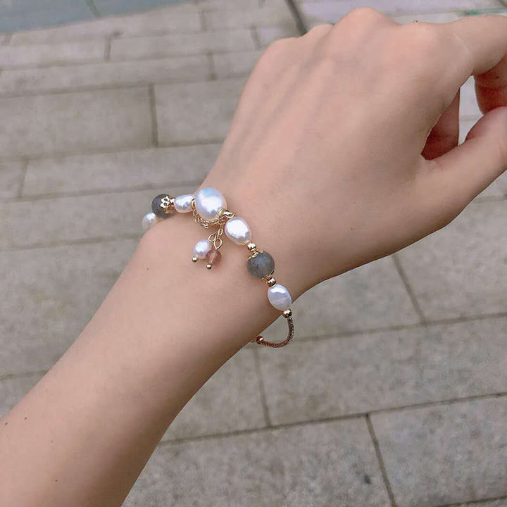Armband Erdbeerquarz Mondstein Perlen elegant am Handgelenk getragen