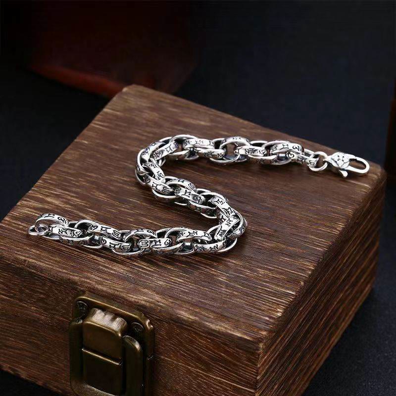 Silbernes Om Mani Padme Hum Armband auf Holzschatulle elegant präsentiert.