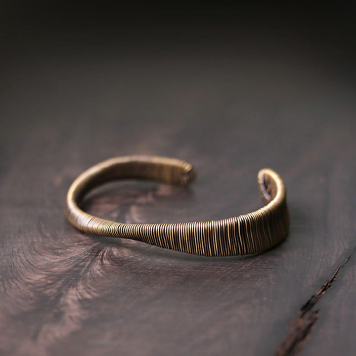 Kupfer Armband mit Rillenstruktur auf dunklem Holzuntergrund elegantes Design