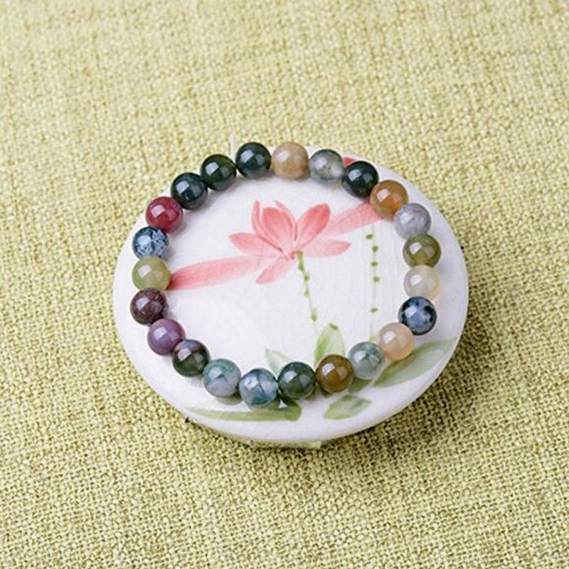 Armband Indischer Achat Yoga Perlen auf weißer Schale Flachlage Naturstein