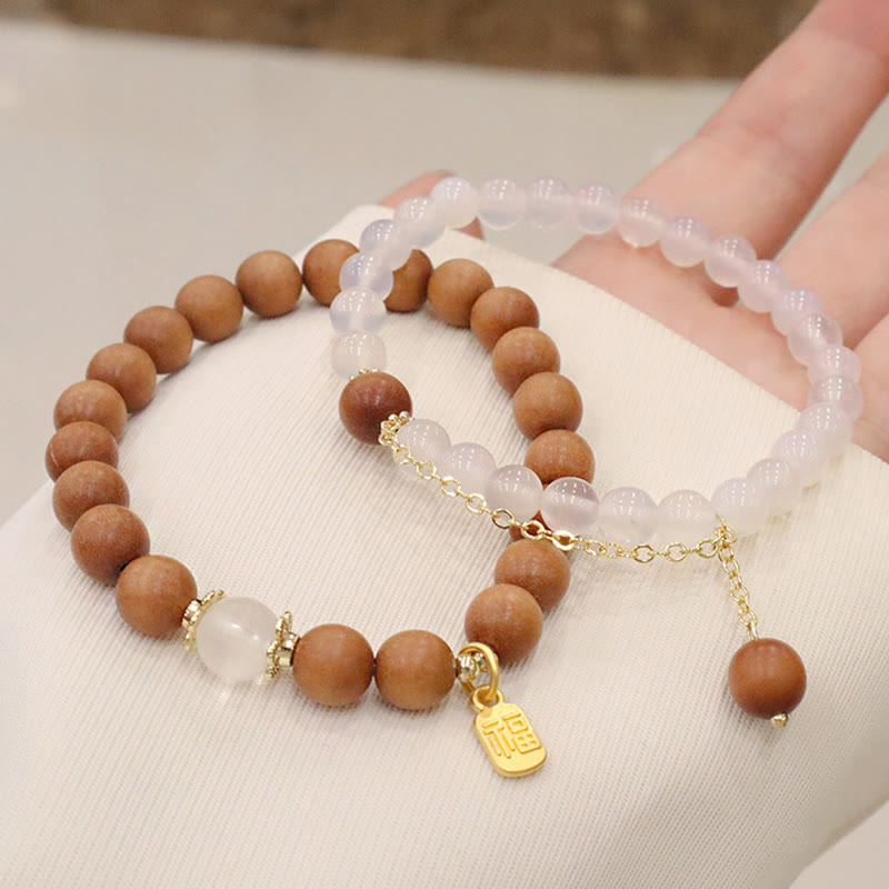 Armband Sandelholz Fu-Zeichen Schutz Rosenquarz elegant getragen Hand