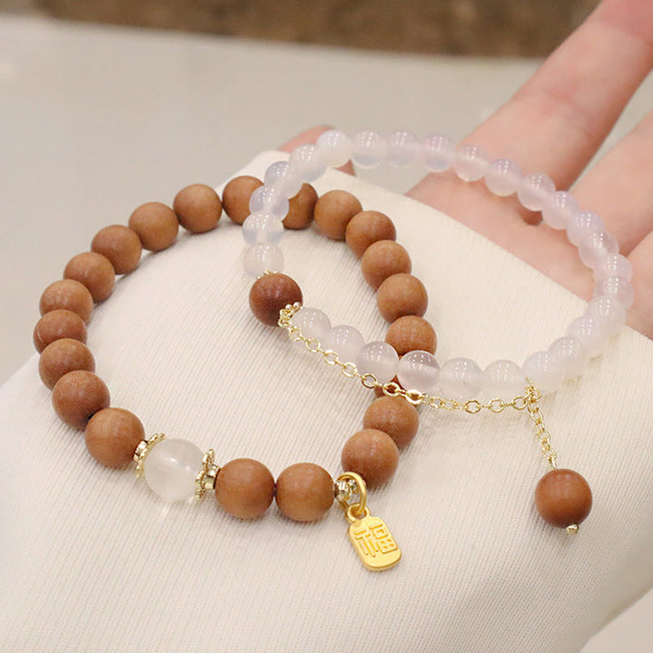 Armband Sandelholz Fu-Zeichen Schutz Rosenquarz elegant getragen Hand
