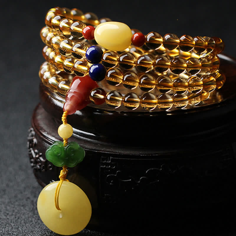 Mehrschichtiges Armband mit goldenem Citrin Anhänger und bunten Steinen.