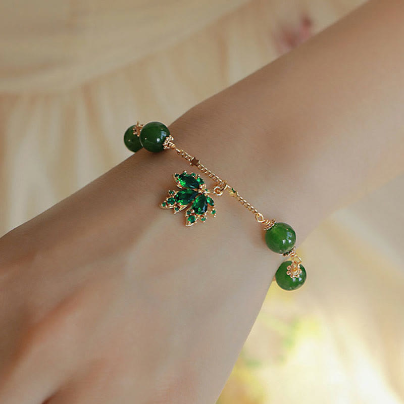Grünes Jade Armband mit Glücksanhänger am Handgelenk getragen elegant