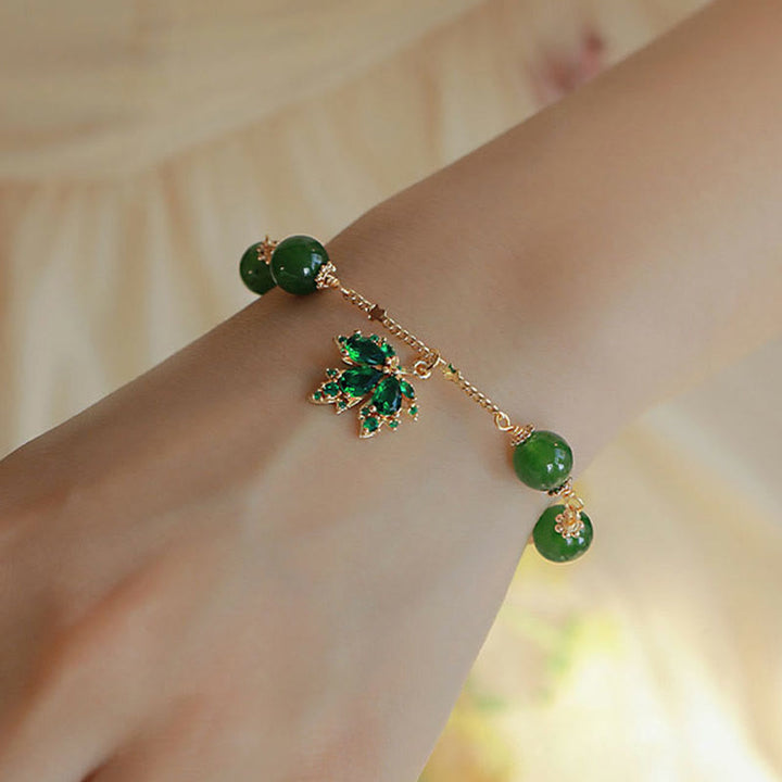 Grünes Jade Armband mit Glücksanhänger am Handgelenk getragen elegant