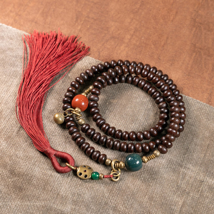 Mala 108 Perlen Bodhi Armband mit roten Quasten und Natursteinen.