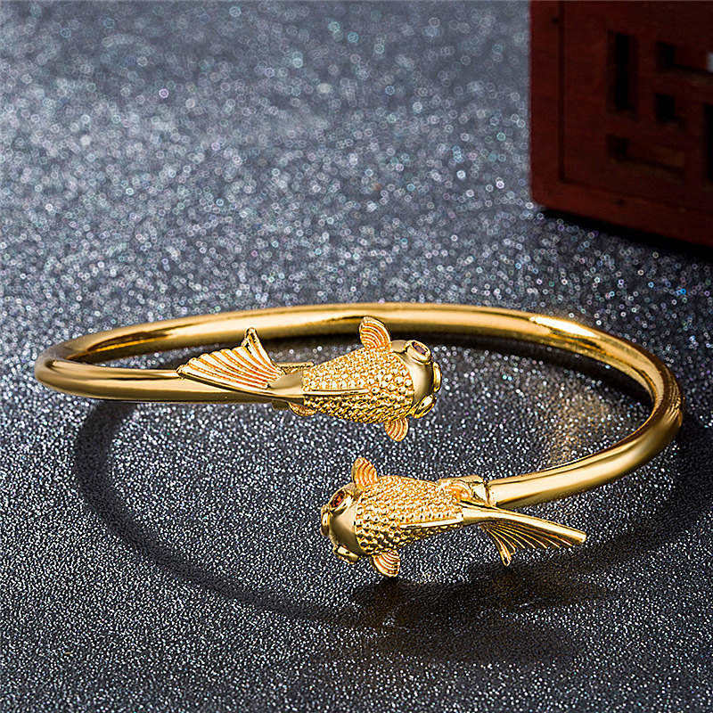 Goldenes Koi Fisch Armband Kupfer auf funkelndem grauem Hintergrund Schmuck