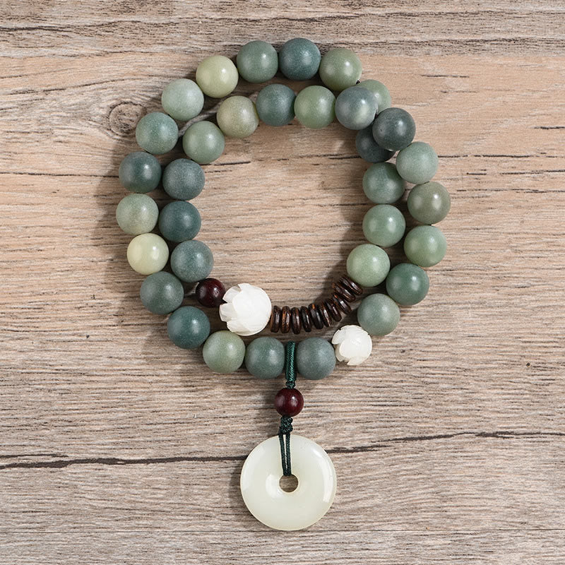 Armband mit grünen Jade-Perlen und weißem Anhänger elegant.