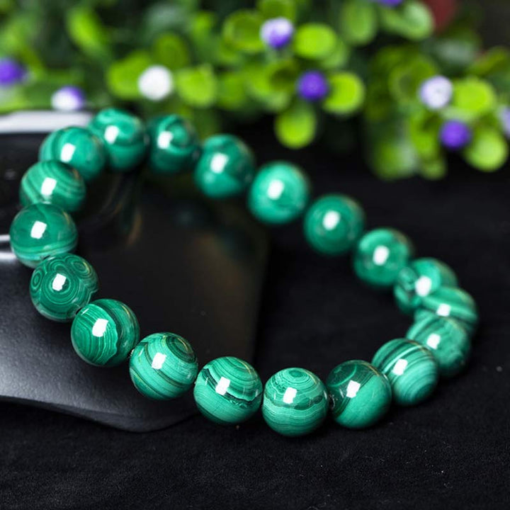 Mala Malachit Armband grüne Perlen Naturstein auf schwarzem Untergrund Nahaufnahme
