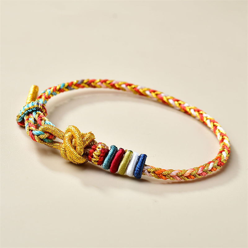 Buntes geflochtenes Armband mit goldenem Knoten und Perlen.