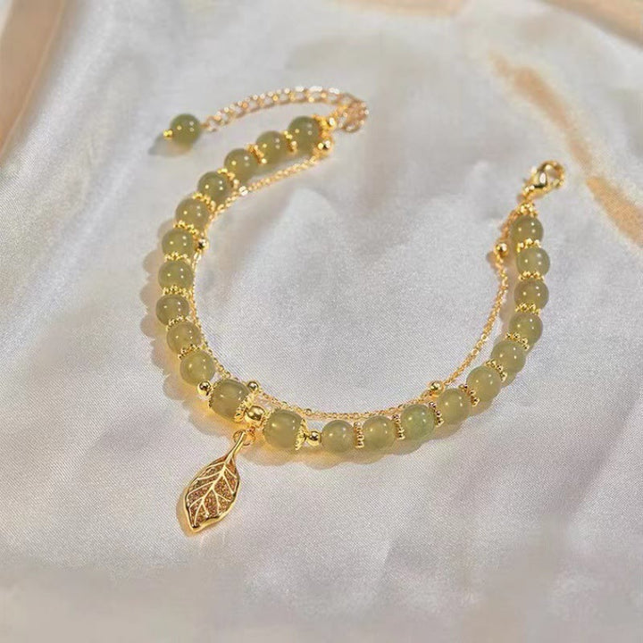 Jade Armband mit goldenem Blatt Anhänger elegant getragen