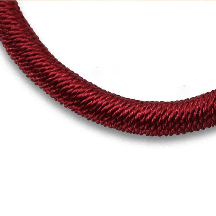 Rotes geflochtenes Armband elastisch getragen Handgelenk Nahaufnahme