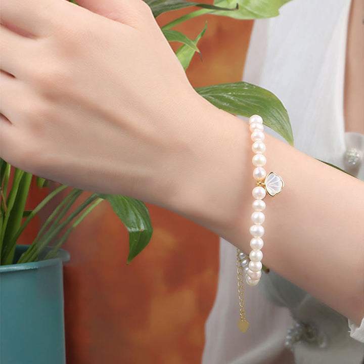 Weißes Perlen Armband mit Kristall Charm am Handgelenk getragen