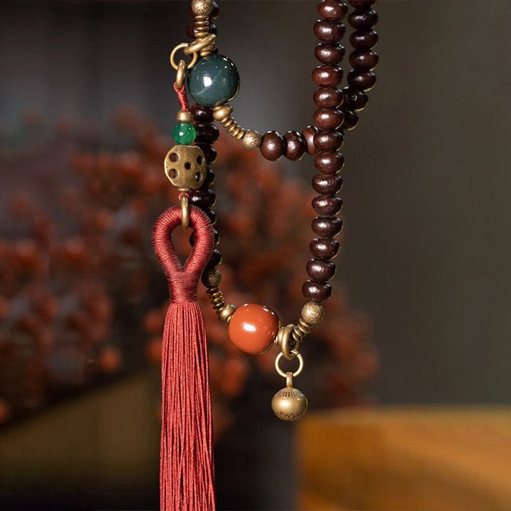 Mala 108 Perlen Bodhi – Stärke Armband mit roten Quasten und Natursteinen.