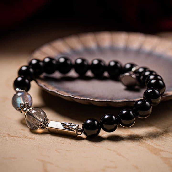Schwarzes Obsidian Armband mit silbernen Perlen elegant präsentiert.