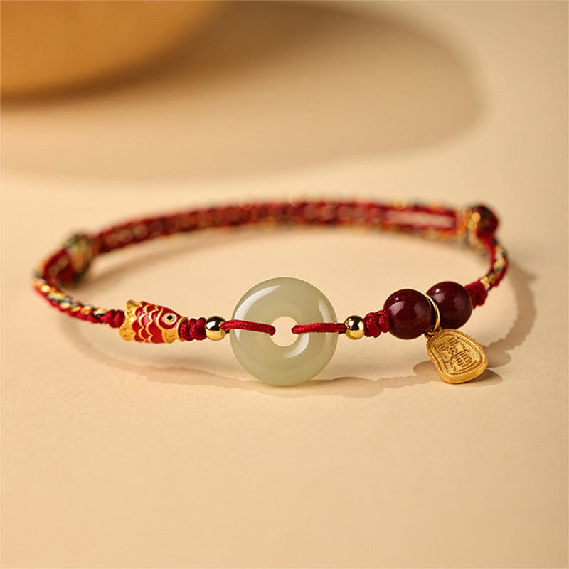 Armband mit Jade-Anhänger, roten Perlen und goldenem Charm elegant.