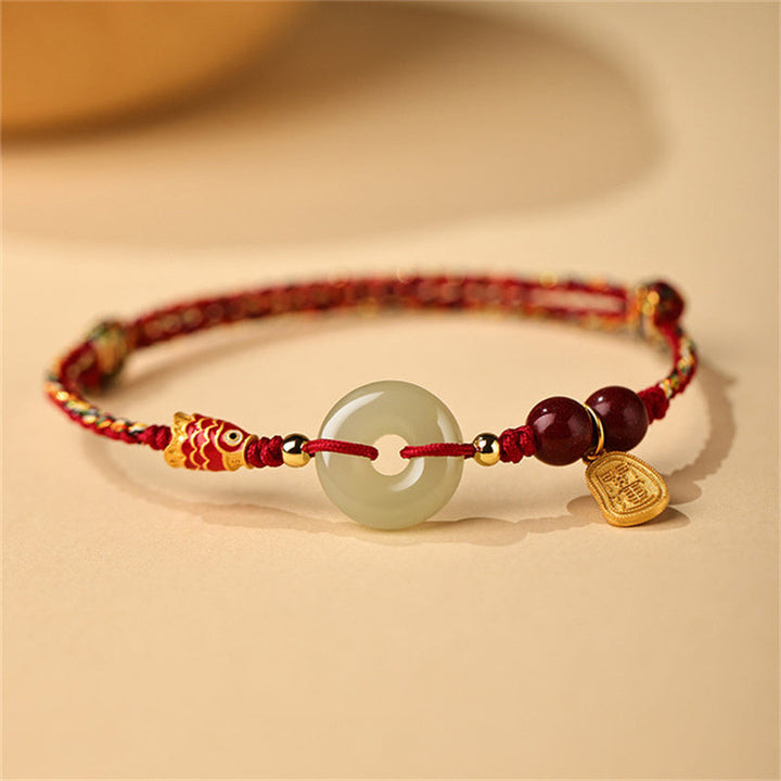 Armband mit Jade-Anhänger, roten Perlen und goldenem Charm elegant.