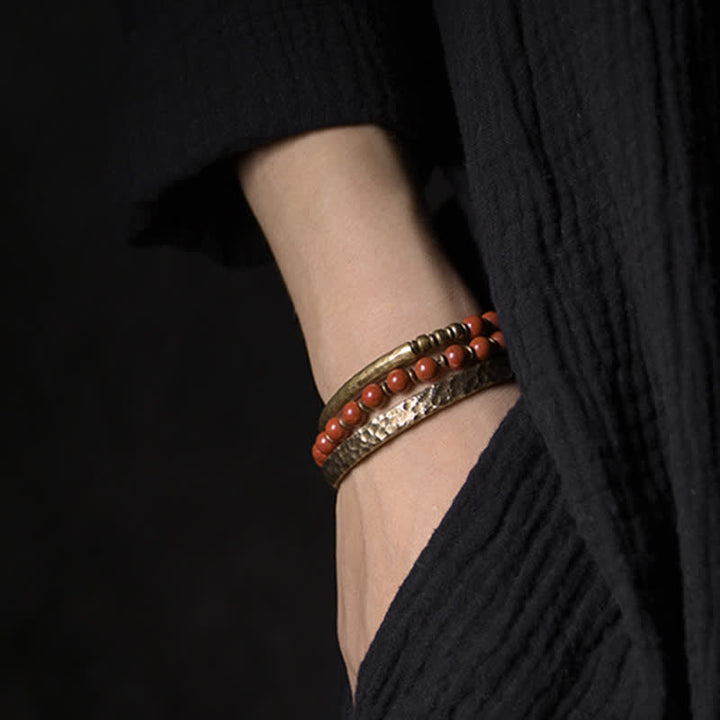 Armband mit roten Perlen und schwarzem Obsidian am Handgelenk getragen