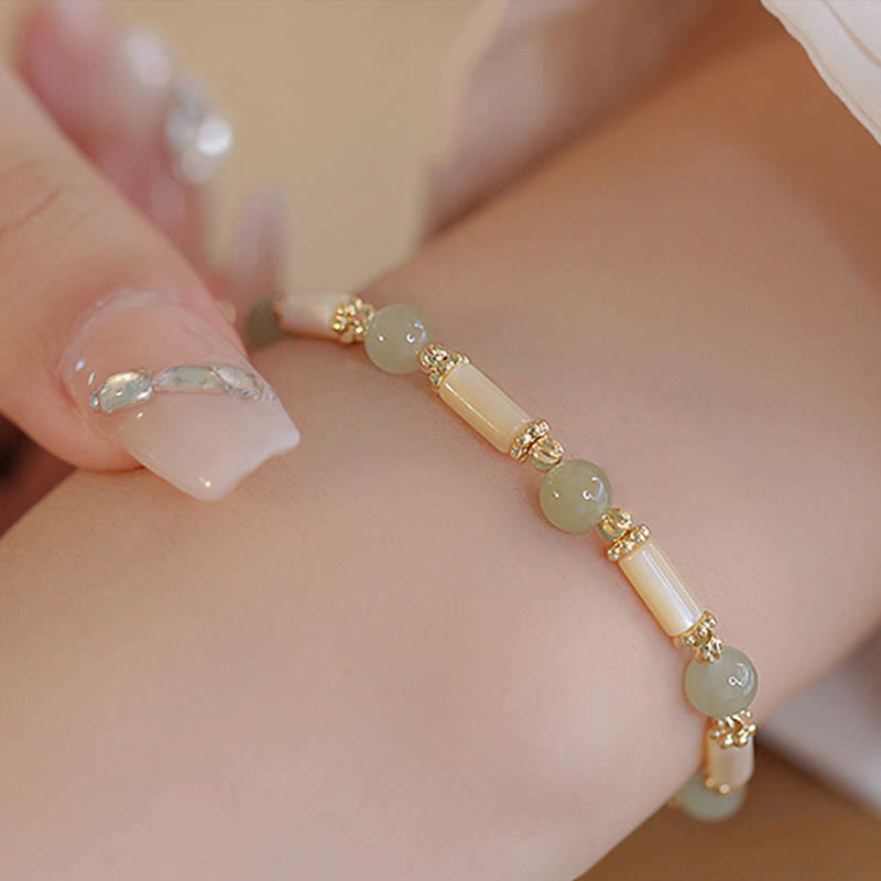 Armband mit Jade und Perlmutt Perlen gold elegant am Handgelenk getragen
