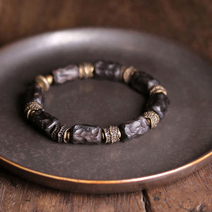 Armband Kupfer Ebenholz mit geschnitzten Perlen und Metallakzenten.