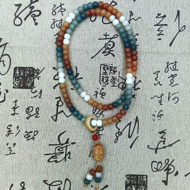 Mala Bodhi Armband mit bunten Steinen auf Schrifttafel.