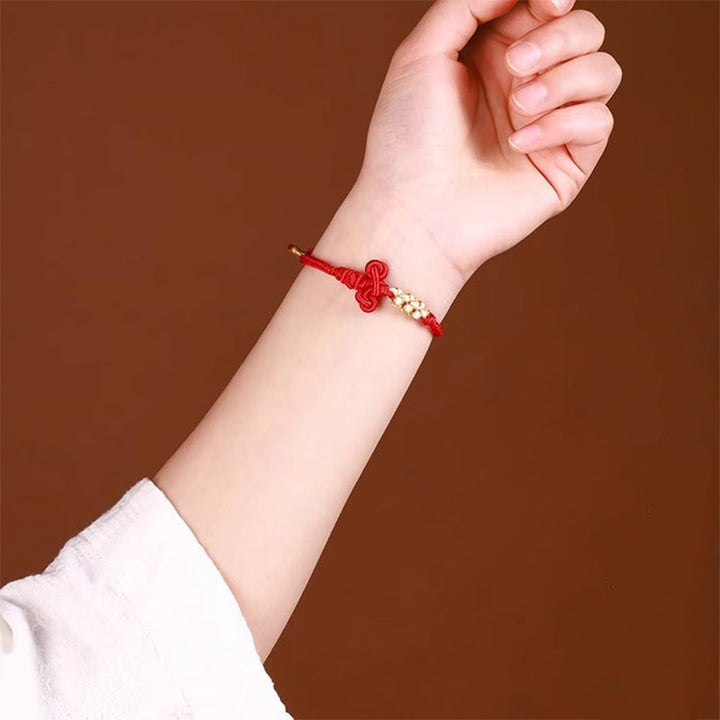 Rotes Armband – Glück & Stärke & Balance mit goldenem Knoten Handgelenk