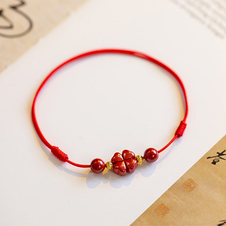 Rotes Armband Zinnober Kleeblatt mit goldfarbenen Perlen Flachlage