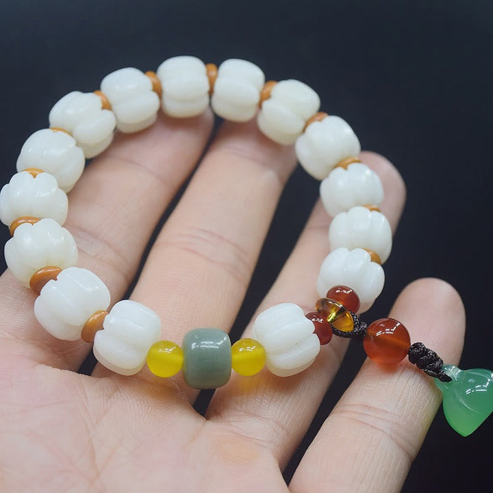 Armband mit weißen Perlen und Achat Anhänger am Handgelenk getragen