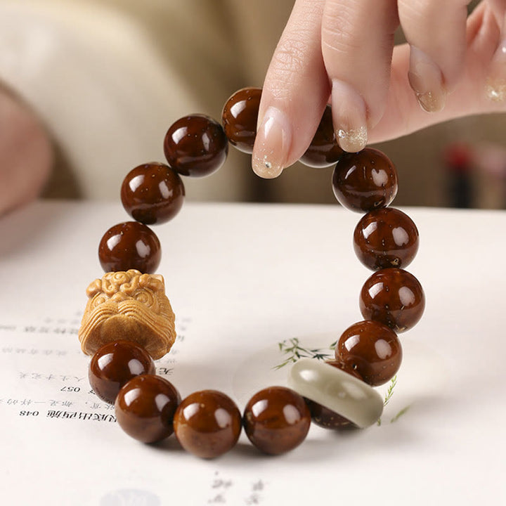 Armband mit braunen Bodhi Samen und tanzender Löwe Schnitzerei.