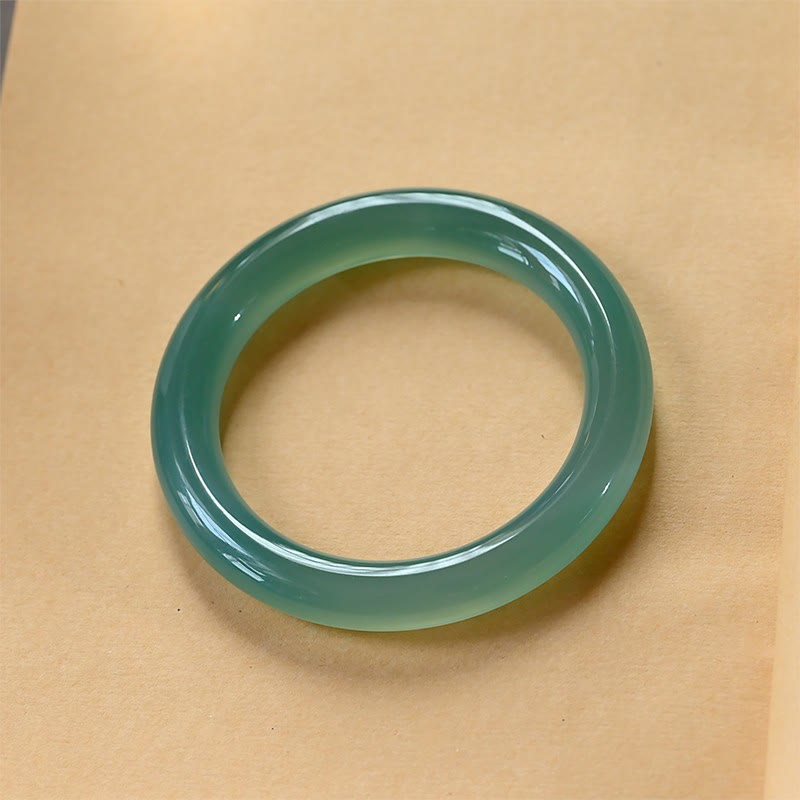 Grünes Chalcedon Armband Armreif auf beigem Hintergrund Stärke