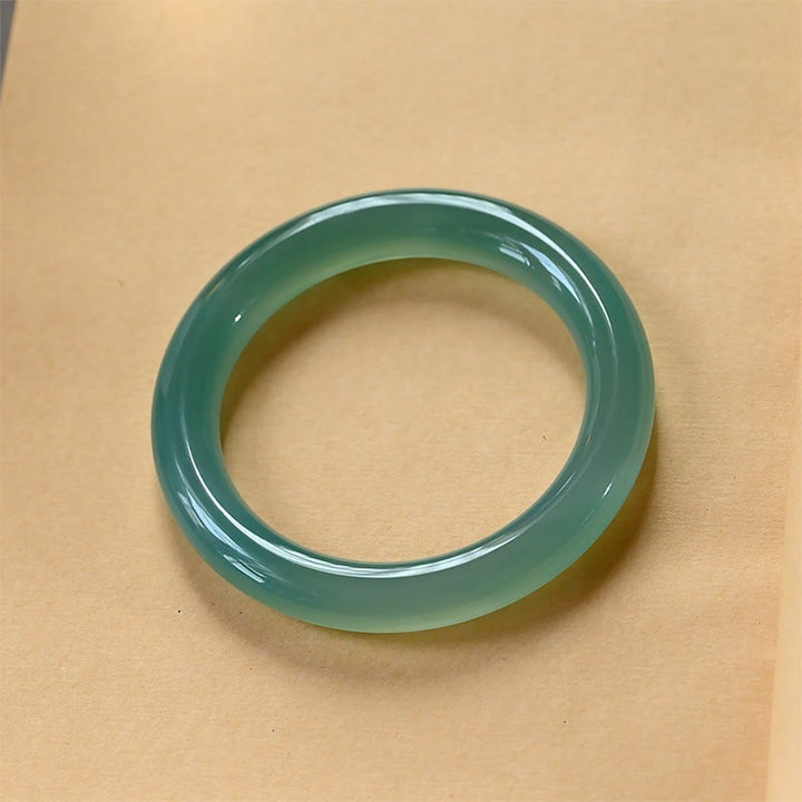 Grünes Chalcedon Armband Armreif auf beigem Hintergrund Stärke