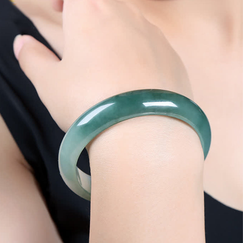 Jade Armband grüner Stein glänzend am Handgelenk getragen elegant