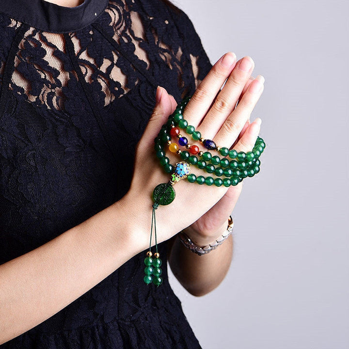 Grüne Mala 108 Perlen Achat Armband an weiblicher Hand getragen.