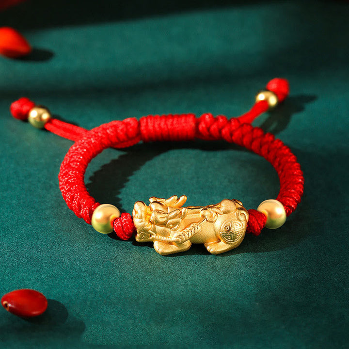 Rotes Seidenschnur Armband mit goldenem Pixiu Wohlstandssymbol.