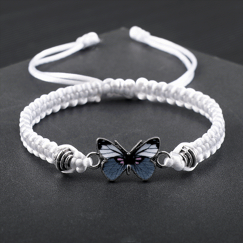 Weißes Armband Schmetterling – Liebe mit Schmetterling Charm auf dunklem Hintergrund