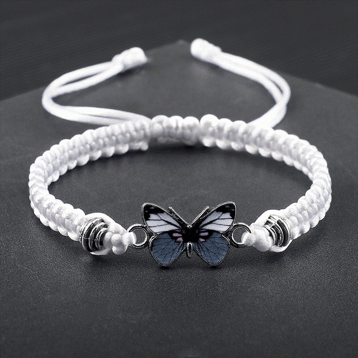 Weißes Armband Schmetterling – Liebe mit Schmetterling Charm auf dunklem Hintergrund