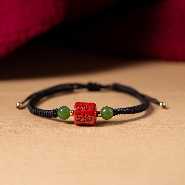 Schwarzes Armband mit rotem Om Mani Padme Hum Anhänger und grünen Perlen