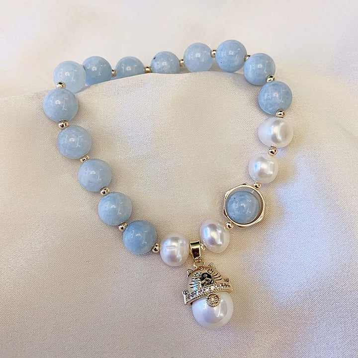 Armband Aquamarin Perle Katze auf heller Oberfläche, blaugrüne Steine mit Perlen
