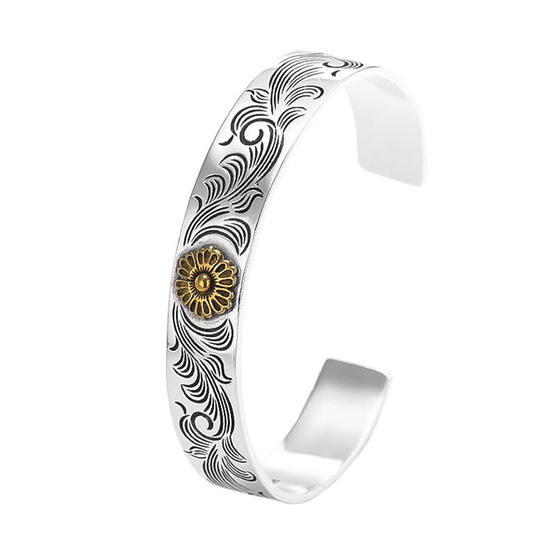 Silbernes Armband mit graviertem Muster und goldenem Blütendetail.