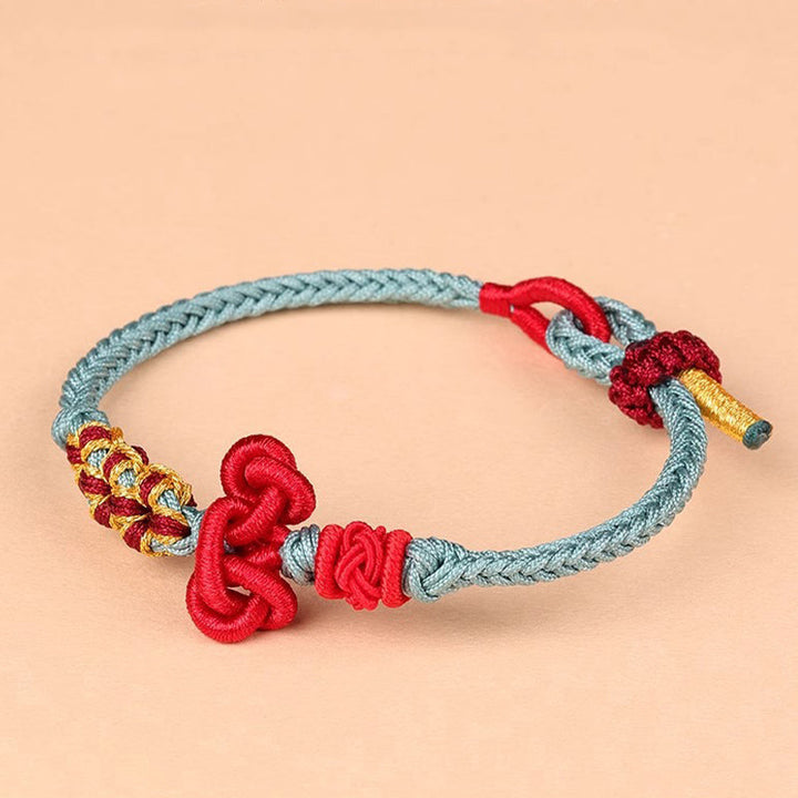 Rotes Seidenstoff Armband mit grauem Geflecht Glück Stärke Balance.
